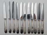 six knives and a knife holder on a table