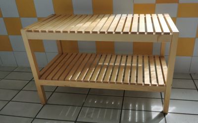 a wooden shelf with a shelf underneath it on a tiled floor