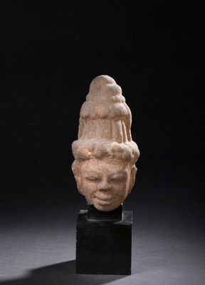 an ancient stone head of a woman on a black stand