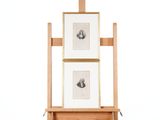 un chevalet en bois sur lequel sont posés deux tableaux