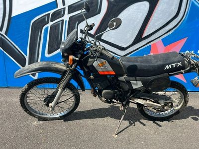 une moto garée devant un mur recouvert de graffitis