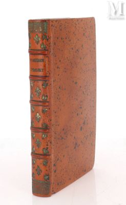 un vieux livre à la couverture brune posé sur une surface blanche