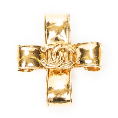 un gros plan d'une croix en or arborant le logo Chanel