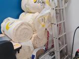 une échelle posée à côté d'un tas de moquettes