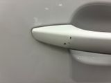 a close up of a door handle on a white car