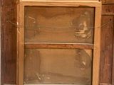 an old wooden cabinet with a glass door on it