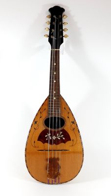 an old wooden mandolin sitting on top of a white surface