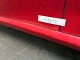 a sticker on the side of a red car that says vrauuto