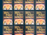 many harry potter books lined up on a table