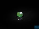 a close up of a green gemstone on a black surface