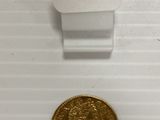 gros plan d'une pièce de monnaie sur une surface blanche avec une étiquette de prix