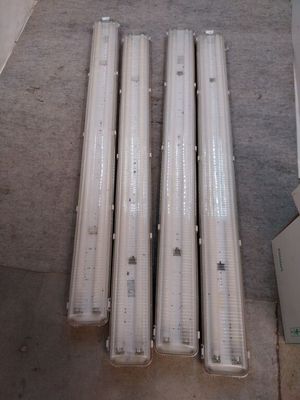 quatre lampes fluorescentes posées par terre dans une pièce