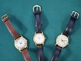 trois types de montres différents posés sur un fond vert