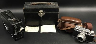 trois vieux appareils photo et une valise posés sur une table
