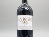 une bouteille de vin posée sur une table blanche