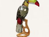 a glass bird sitting on top of a wooden stand