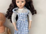 two dolls sitting next to each other on a white surface