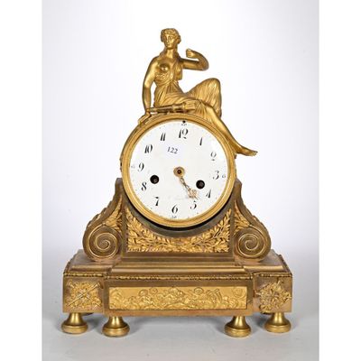 une horloge en or sur laquelle est assis un homme