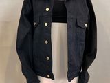 a black jacket on a mannequin stand on a white background