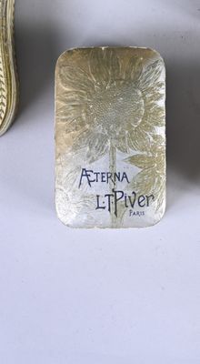 a silver plate with a flower on it next to a pair of shoes