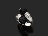 un gros plan d'une bague sertie d'un diamant noir et blanc sur une surface noire