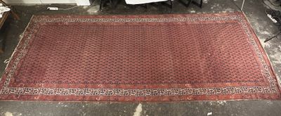 On voit une image représentant un tapis rouge posé sur le sol d'une pièce.