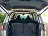 the back of a silver car with its trunk open and the seats down