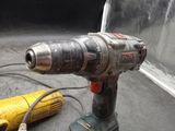 a drill that is sitting on a table next to a yellow cord