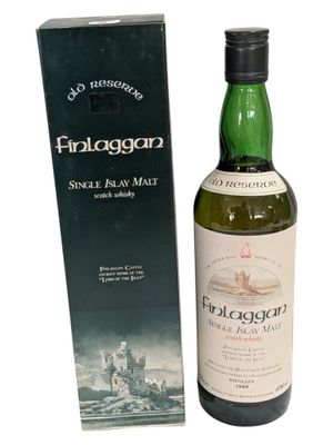 a bottle of whisky sitting next to a box on a white surface