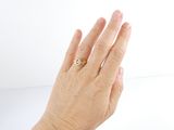 a woman ' s hand with a gold ring on it