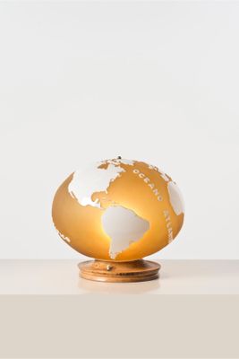 un globe doré et blanc posé sur un socle en bois