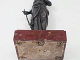 a statue of a woman holding a sword and a box