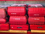 many red boxes stacked on a shelf in a garage