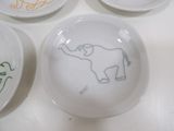 several plates with drawings of animals on them on a table