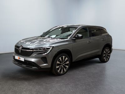 un SUV argenté garé dans une pièce au sol noir