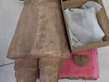 une statue en bois représentant une femme tenant une boîte