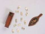a lot of dice pieces and a wooden paddle on the table