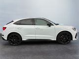 a white audi suv parked in a parking lot on a cloudy day