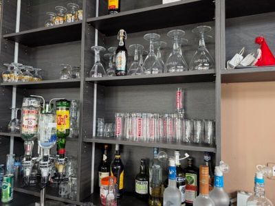 de nombreuses bouteilles et verres sur les étagères de la pièce