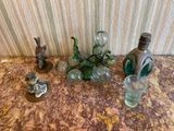 une table sur laquelle se trouvent une bouteille, un vase en verre et d'autres objets