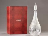 an image of a glass perfume bottle next to a red box