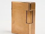 un briquet doré posé sur une surface blanche