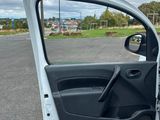 the door of a white car is open on a parking lot