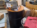 a large black barrel with a red shirt on top of it