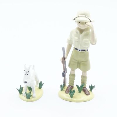 deux figurines représentant un homme et un chien sur un fond blanc