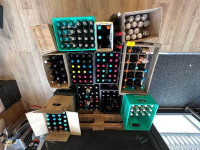 de nombreuses bouteilles de vin posées sur une palette dans une pièce
