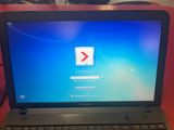 ordinateur portable avec l'écran de démarrage de Windows 7 posé sur une table rouge