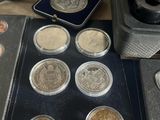 some coins are sitting on a table next to a box of coins