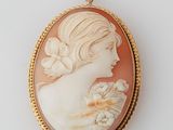 Un pendentif représente une femme avec une fleur dans les cheveux