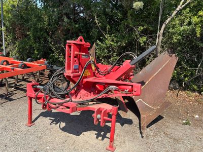 un tracteur rouge équipé d'une charrue